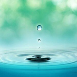 close up of three droplets in a blurred green background